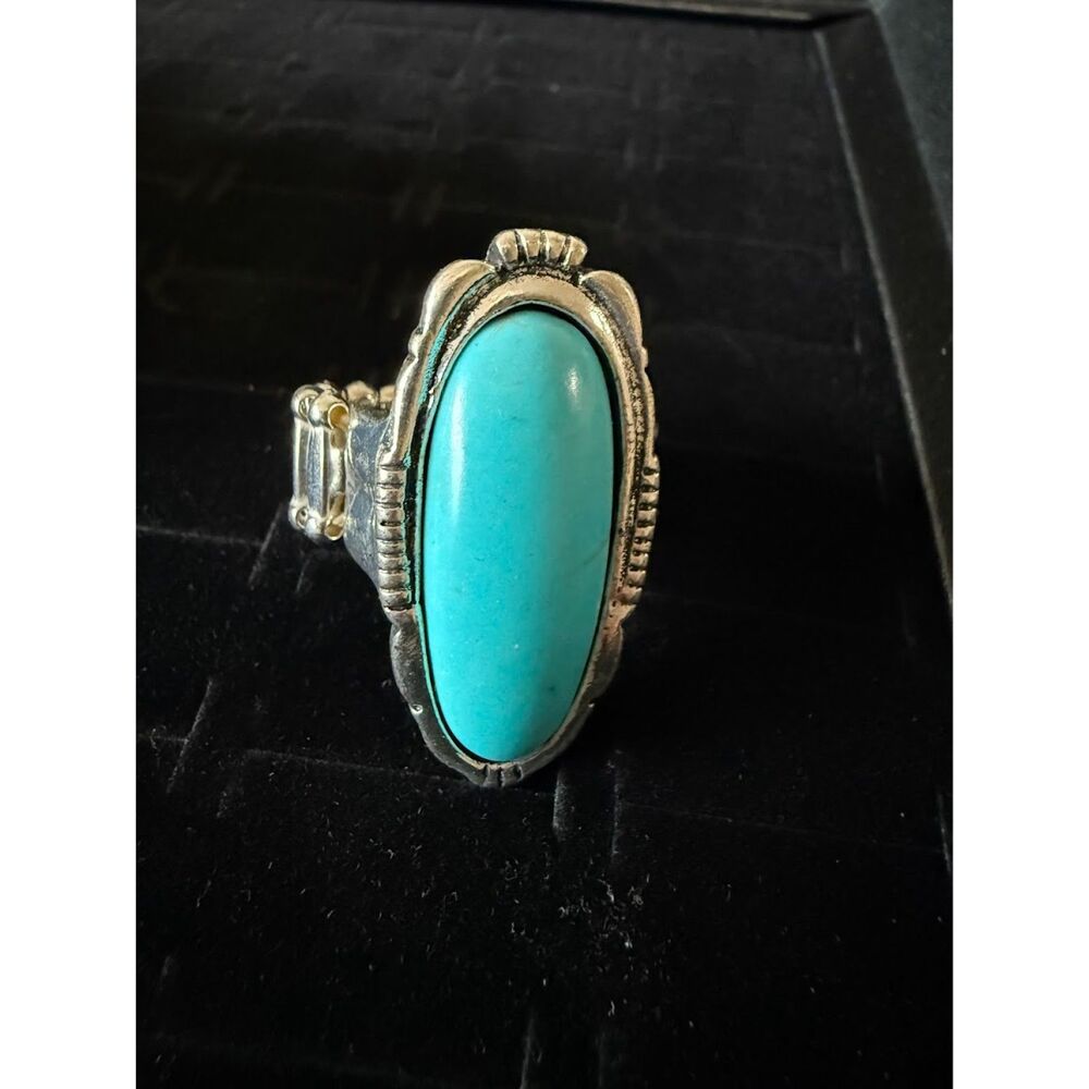 silver tone oval with solid  blue stone, stretch wide band for comfort fit.